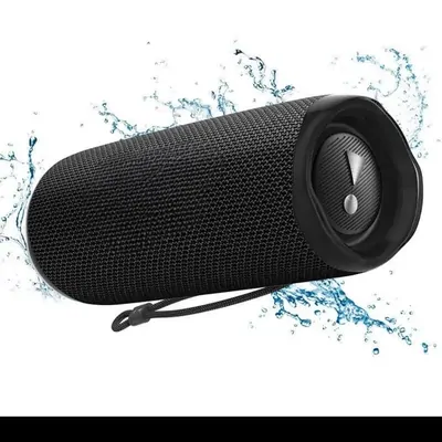 A black cylindrical portable speaker standing upright, with water droplets splashing around it