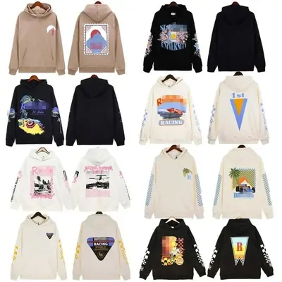 Twelve printed hoodies and sweatshirts in cream, black and navy, arranged in a four by three grid