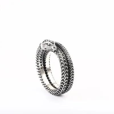 A silver coiled snake-shaped ring photographed on a plain white surface